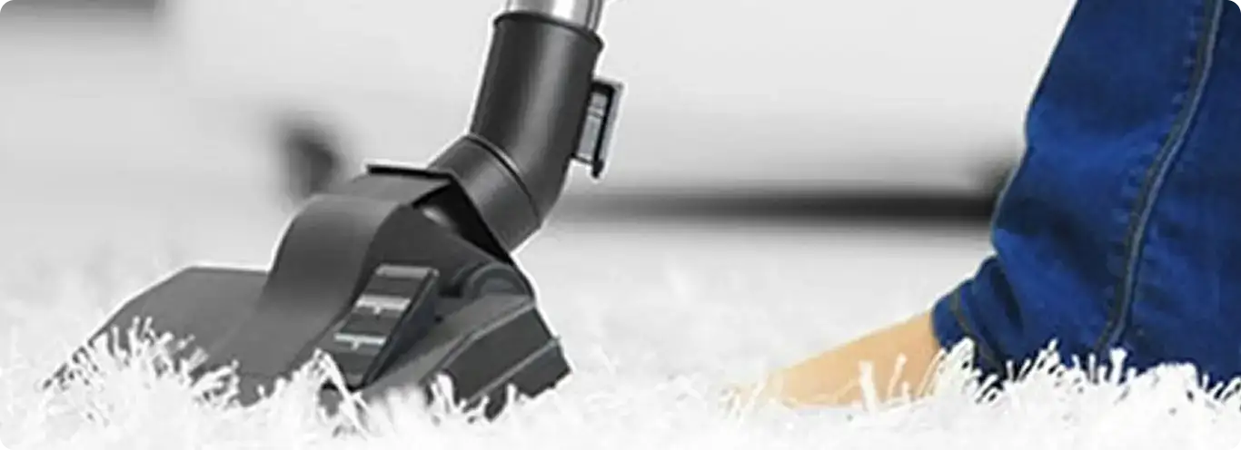 Close-up of a professional vacuuming a white carpet in Boone.
